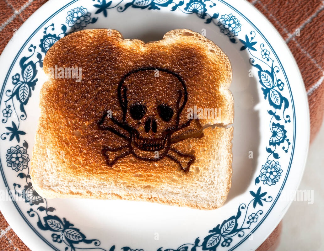 skull-and-crossed-bones-burned-into-a-piece-of-toast-on-a-plate-celiac-CNBTRG